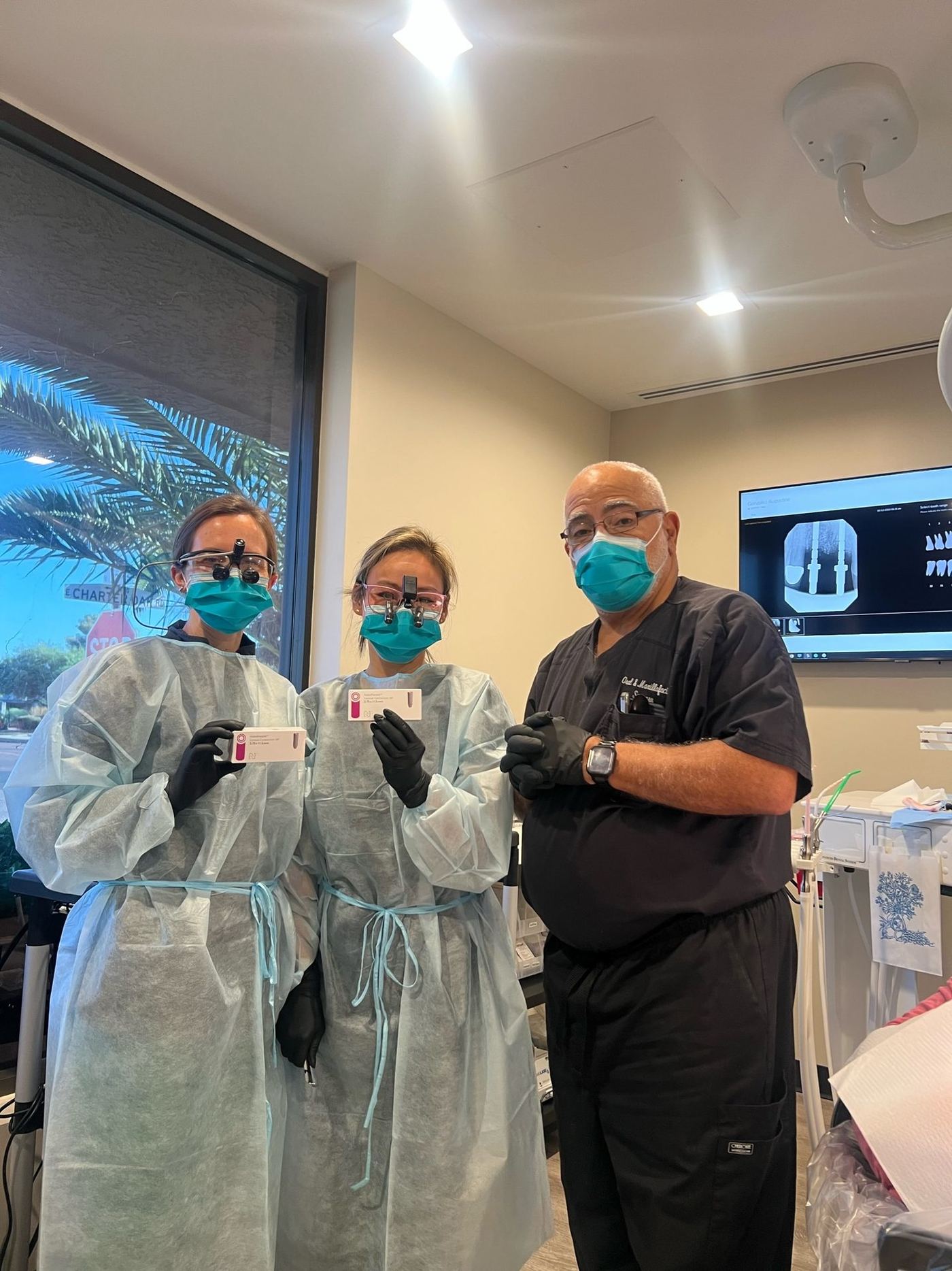 Instructor coaching two dentists during hands-on implant training